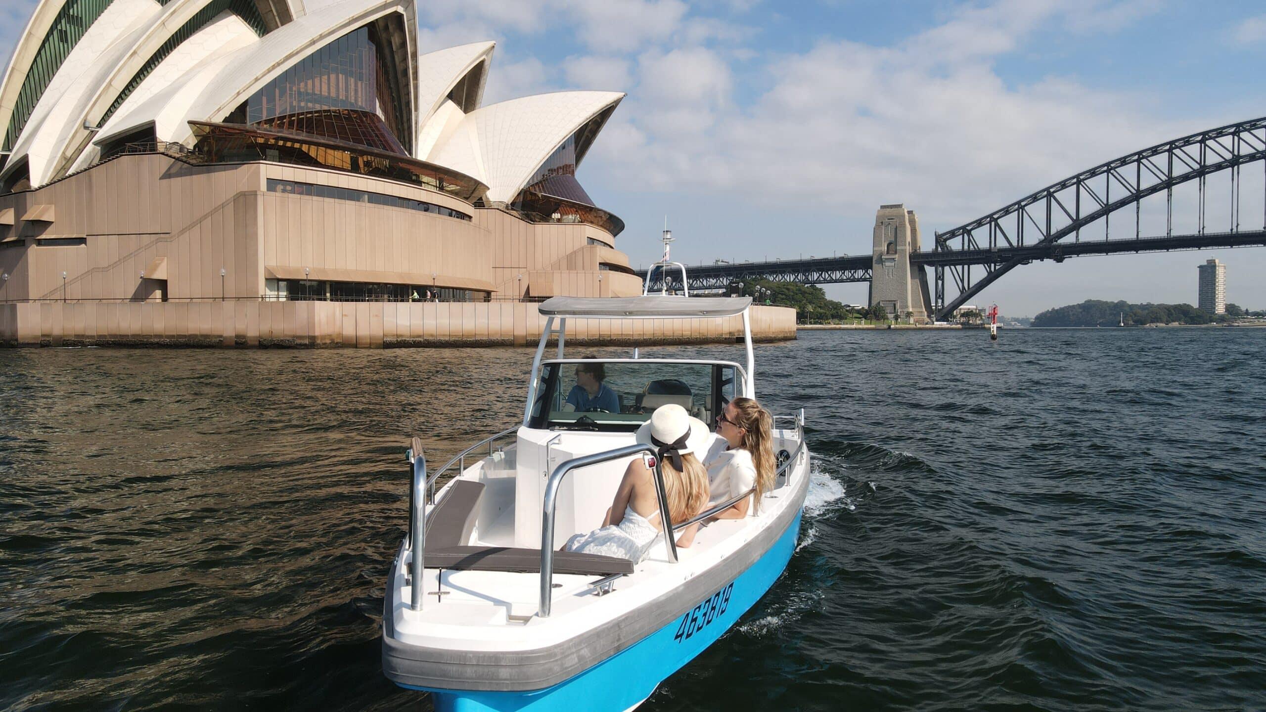 A self-drive boat leaving Mosman on Sydney Harbour with the Opera House and Harbour Bridge behind